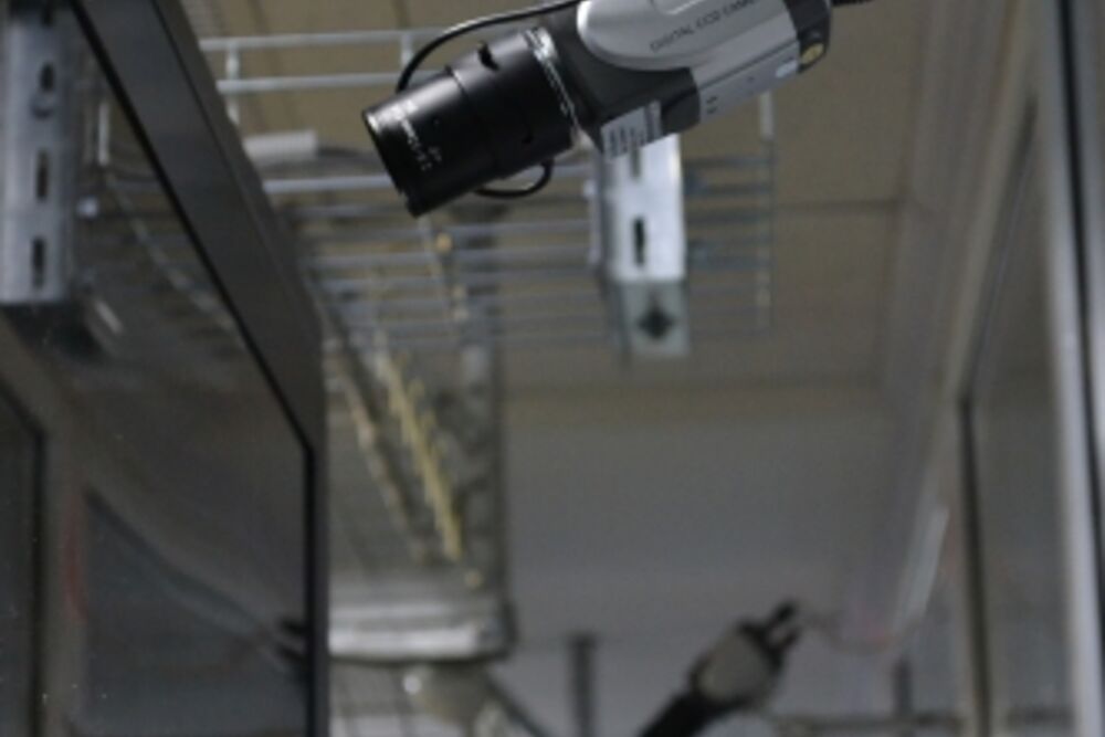 A surveillance camera above a row of server cabinets